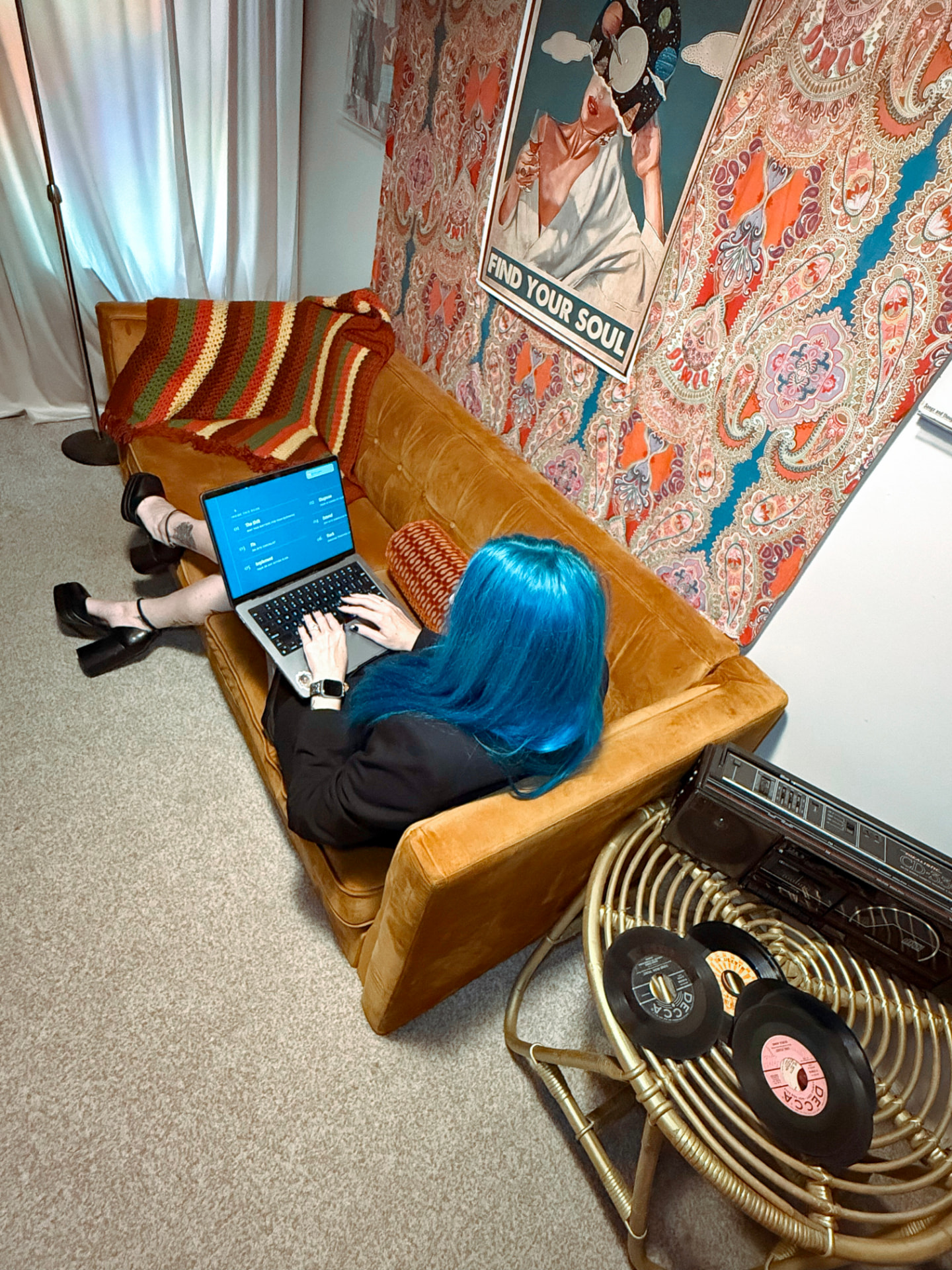 Amanda O’Green working on her laptop from the gold velvet sofa in the records room